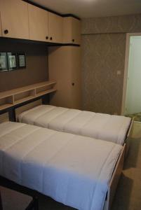 two beds in a small room with cabinets at westclif 2 in Blankenberge