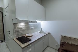 uma cozinha branca com um lavatório e um fogão em Švitrigailos 7 em Vilnius