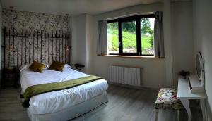 a bedroom with a bed and a window at La Onda in Ramales de la Victoria