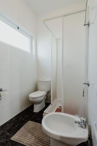 a white bathroom with a toilet and a sink at City View Gardens I in Funchal
