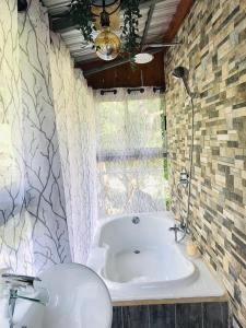 La salle de bains est pourvue d'une baignoire et d'un lavabo. dans l'établissement Cabaña treehouse Mountain View, à San Isidro