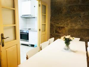 uma cozinha com uma mesa com um vaso de flores sobre ela em D'ouro no Porto