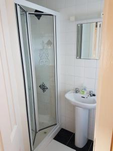 een badkamer met een douche en een wastafel bij Granny Dens in Donegal