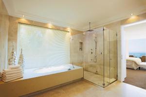 a bath room with a tub and a shower at The Clarendon - Bantry Bay in Cape Town
