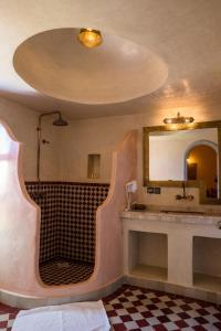 ein Bad mit einem Waschbecken und einem Spiegel in der Unterkunft Riad Azawad in Merzouga