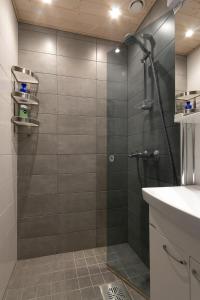 a shower with a glass door in a bathroom at Piriko Studio Apartments in Rovaniemi