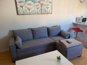 a living room with a blue couch and a table at Calle Juan Lirola in Almería