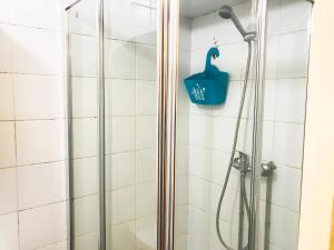 um chuveiro com uma cesta azul na parede em D'ouro no Porto mais 39 fotografias
