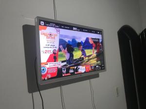 a flat screen tv hanging on a wall at Suites próximo ao rio Jaguareguava em Bertioga in Bertioga