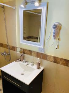 a bathroom with a sink and a hair dryer on the wall at Departamentos Le Forêt in Mar de Ajó