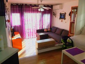 a living room with purple curtains and a couch at LOFT DOS MARES- Parking Gratis - 1 Línea de Mediterráneo - Terraza - WIFI in La Manga del Mar Menor