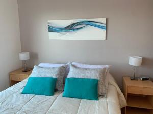 1 dormitorio con 1 cama con 2 almohadas azules en Buenos Aires View - Apart 2 Amb sobre Av Corrientes en Buenos Aires