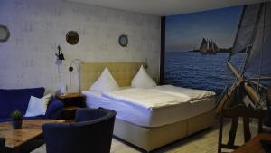 a bedroom with a bed and a sailboat in the water at Hotel Zierow - Urlaub an der Ostsee in Wismar