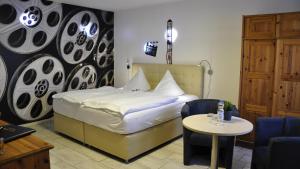 ein Schlafzimmer mit einem Bett, einem Tisch und einem Stuhl in der Unterkunft Hotel Zierow - Urlaub an der Ostsee in Wismar
