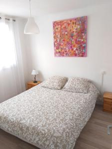 1 dormitorio con 1 cama y una pintura en la pared en Aux Alyscamps en Arles