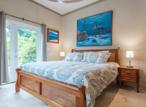 a bedroom with a bed and a painting on the wall at Belizean Cove Estates Luxury Beachfront Villa in San Pedro