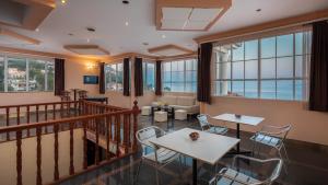 Cette chambre comprend des tables, des chaises et des fenêtres. dans l'établissement Family Beach Rooms, à Omiš