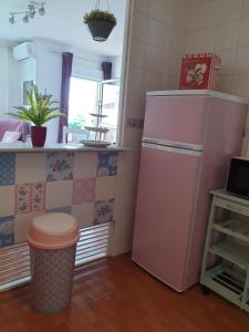 a kitchen with a pink refrigerator and a window at Sol y Luz in Isla del Moral