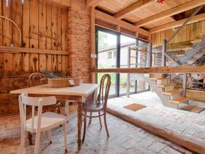 a dining room with a table and chairs and a staircase at Koko Ryku Agroturystyka in Nowa Ruda