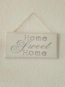a sign that reads home sweet home hanging on a wall at Sol y Luz in Isla del Moral