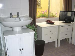 a bathroom with a sink and a vanity with a tv at Citadel House Hotel in Plymouth