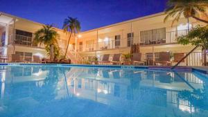 a swimming pool in front of a hotel at night at Soleado Hotel in Fort Lauderdale