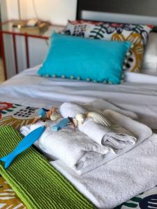 a bed with towels and a blue spoon on it at Starfish Seaside Studio in Artemida