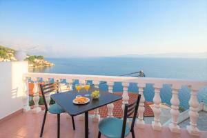 un tavolo e sedie su un balcone con vista sull'oceano di Family Beach Rooms a Omiš (Almissa)