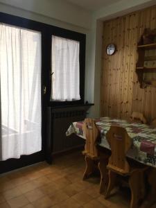 comedor con mesa, sillas y reloj en Residence Il Cristallo en Ovindoli