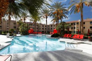 a large swimming pool with chairs and palm trees at Silver Sevens Hotel & Casino in Las Vegas