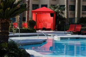 une grande piscine avec des chaises rouges et une tente rouge dans l'établissement Silver Sevens Hotel & Casino, à Las Vegas