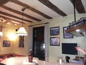 una sala da pranzo con tavolo e soffitto con travi a vista di Hotel Blaues Haus a Otterberg