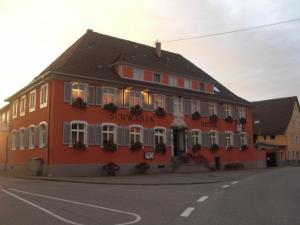 a large red building with flowers on the windows at Hotel & Restaurant Zum Schwanen in Neuried