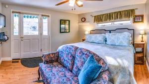 1 dormitorio con 1 cama y 1 sofá en Abigail's Bed and Breakfast Inn en Ashland