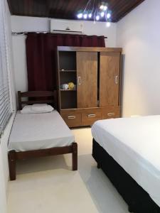 ein Schlafzimmer mit 2 Betten und einer Kommode darin in der Unterkunft COACHHOSTEL7 in São Paulo