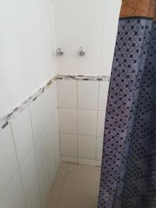a bathroom with a shower with a blue shower curtain at Cabañas Patricia Licanray in Licán Ray