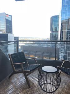 a chair and a table on a balcony with a view at The York by Swiss-Belhotel in Sydney