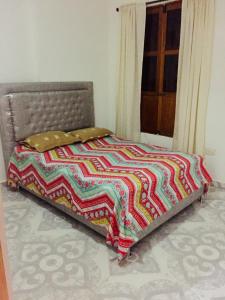 a bed with a colorful quilt on it in a room at Casa Edith in Cartagena de Indias
