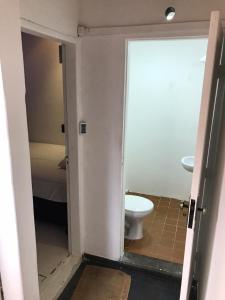 een badkamer met een toilet en een deur open bij COACHHOSTEL7 in Sao Paulo
