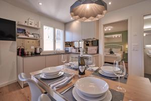 a kitchen with a table with plates and wine glasses at City Center Apartment with Mountain View in Interlaken