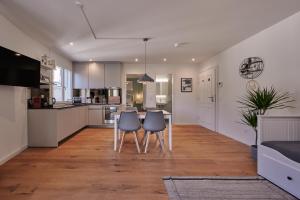 a kitchen and living room with a table and chairs at City Center Apartment with Mountain View in Interlaken