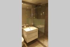La salle de bains est pourvue d'un lavabo et d'une douche. dans l'établissement Modernes Apartment Duisburg, à Duisbourg