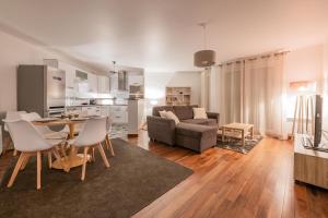 a living room with a couch and a table and chairs at EDEN PARK LUXE DISNEY in Montévrain