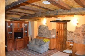 sala de estar con sofá y pared de piedra en Casa el Fanoso, en Luarca