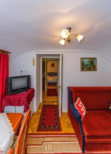 a living room with a red couch and a television at Barokk Vendégház in Eger