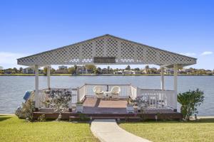 a gazebo on the water with two chairs on it at Lovely Home Only 15mins from Downtown NOLA in New Orleans