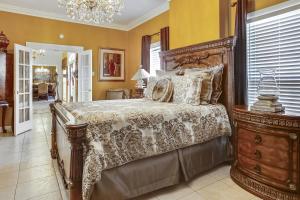 ニューオーリンズにあるLovely Home Only 15mins from Downtown NOLAの大きなベッドとシャンデリアのある寝室