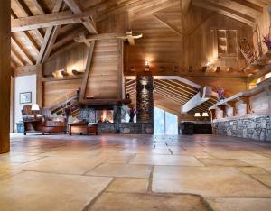 a large room with a stone fireplace and wooden ceilings at Résidence Les Alpages De Champagny in Champagny-en-Vanoise