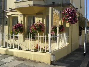 a white fence in front of a building with flowers at Citadel House Hotel in Plymouth