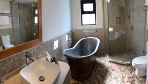 a bathroom with a tub and a sink and a toilet at Guayaba Inn Boutique Hotel in San Cristóbal de Las Casas